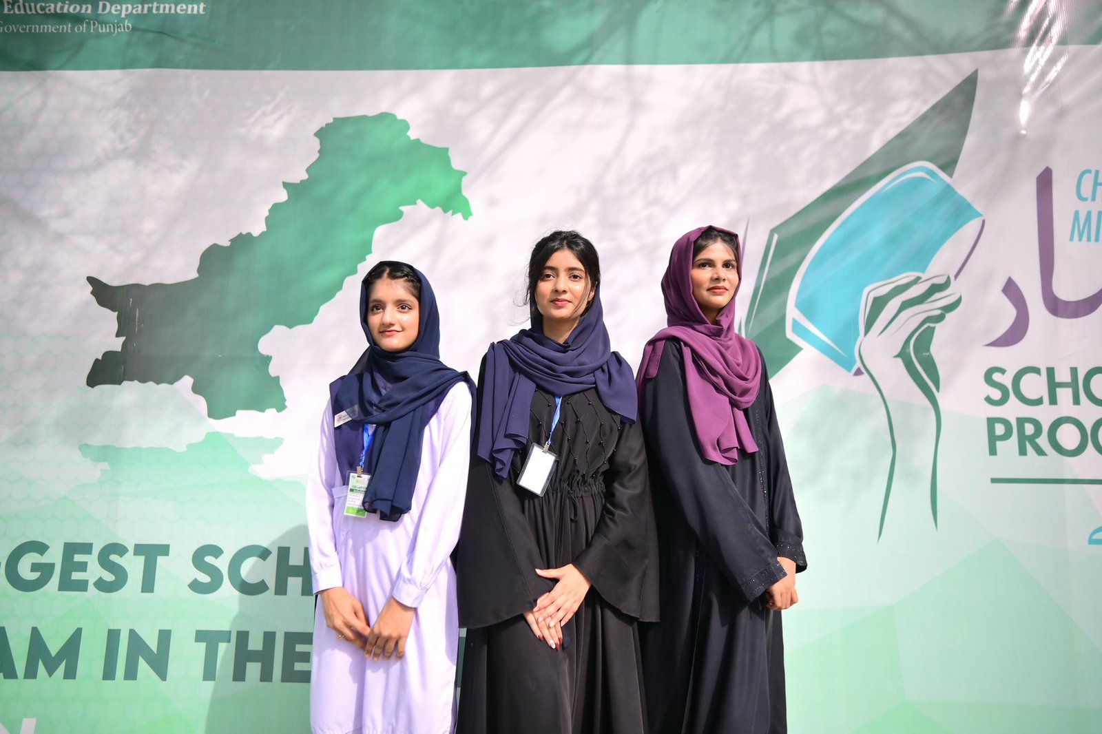 Students at the Honhaar Scholarship event beside a large scholarship board
